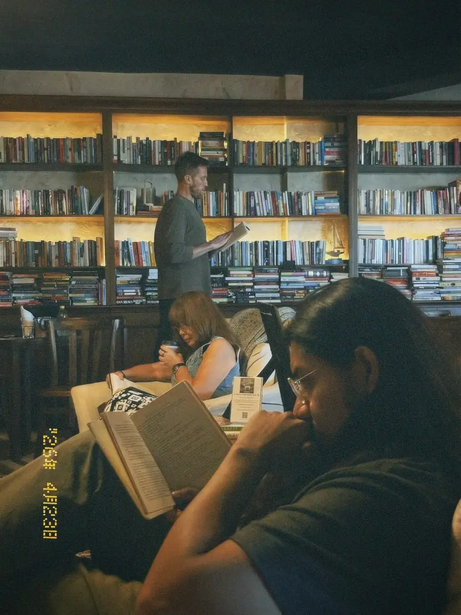 Personas leyendo entre estanterías
